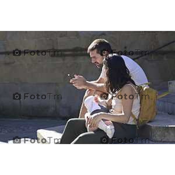Tiziano Manzoni/LaPresse2 5-9- 2025 Italia Cronaca Bergamo Bergamo, nel cuore di Città Alta turisti allatta bambino seduta sui gradini L\'allattamento in pubblico è un atto naturale e un\'esigenza fisiologica che rientra nel diritto della donna e