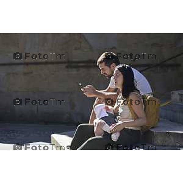 Tiziano Manzoni/LaPresse2 5-9- 2025 Italia Cronaca Bergamo Bergamo, nel cuore di Città Alta turisti allatta bambino seduta sui gradini L\'allattamento in pubblico è un atto naturale e un\'esigenza fisiologica che rientra nel diritto della donna e